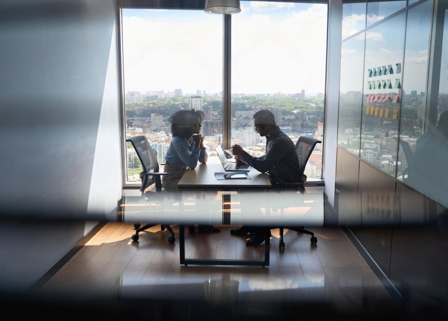 HR manager and employee having a private termination discussion in a Dubai office overlooking the city